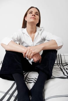 Mid adult woman sitting on the bed and thinking