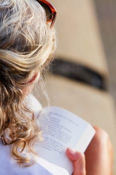 Rear view of a woman holding a book
