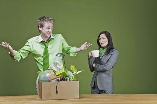 Businessman with his belongings and a businesswoman holding a cup of coffee