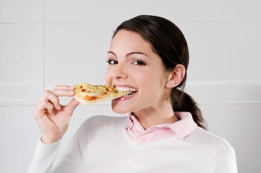 Female chef eating a slice of pizza