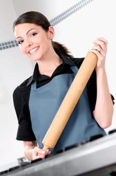 Portrait of a female chef holding a rolling pin and smiling