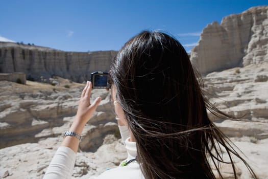 Rear view of a woman photographing with a digital camera