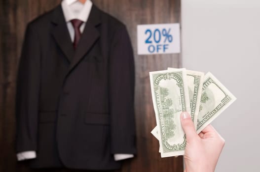 PersonŽs hand holding currency notes in a clothing store