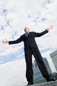 Low angle view of a businessman standing with his arms outstretched