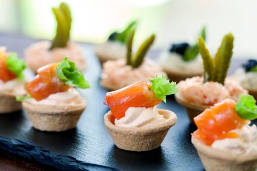 Macro close up of Mini puff pastry tartlets with smoked salmon,creamy crab and savory filling..