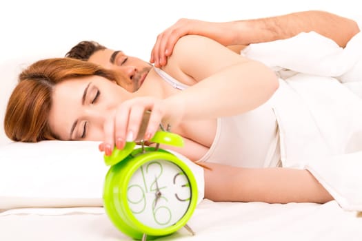 Couple is sleeping and the alarm clock starts to ring - time to wake up!