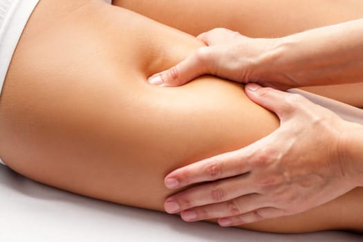 Macro close up of Physiotherapist hands massaging hamstring on female athlete.