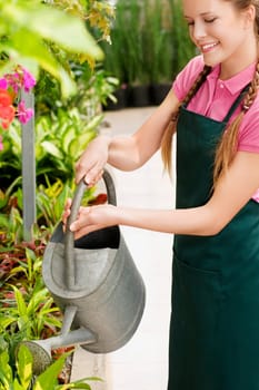 Woman watering plants in a greenhouse