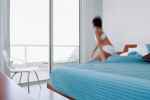 Rear view of a young woman waking up from the bed