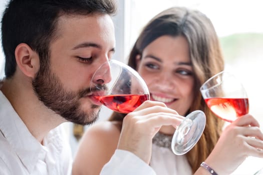 Close up portrait of Couple enjoying and drinking wine at tasting.