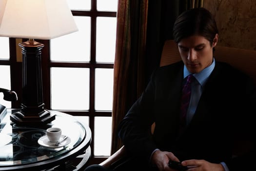 Businessman text messaging on a mobile phone, Biltmore Hotel, Coral Gables, Florida, USA