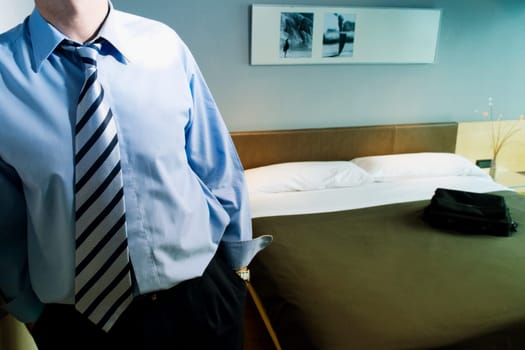 Mid section view of a businessman standing with his hands in his pockets