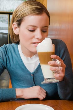 Young woman drinking cappuccino