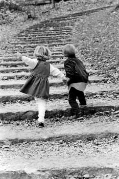 Rear view of a boy with his sister moving up on steps