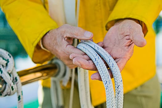Mid section view of a senior manŽs hand holding ropes