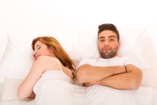 Young depressed couple in bed - daylife problems concept