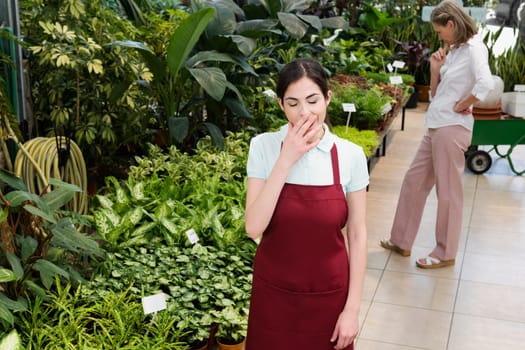 Woman yawning in a greenhouse