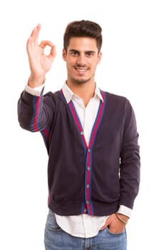 Handsome young man signaling ok, isolated over a white background