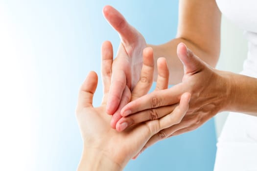 Macro close up of therapist hands doing curative massage on female hand.