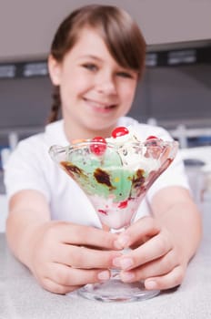 Girl holding a glass of ice cream and smiling