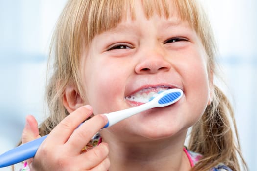 Macro close up of little girl having fun brushing teeth.