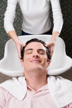 Mid adult man having a hair wash in the hair salon