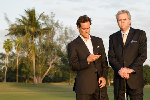 Golfer text messaging with another golfer standing beside him, Biltmore Golf Course, Coral Gables, Florida, USA