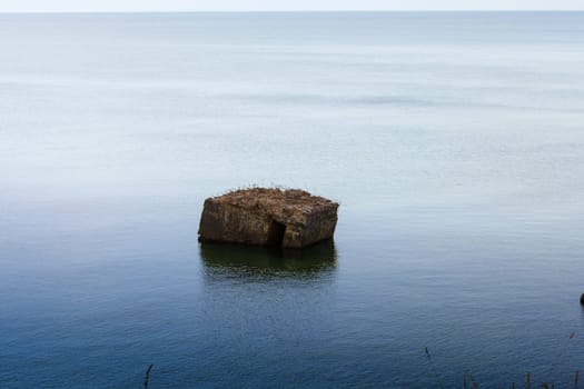 Old German bunker is rinsed out in the sea on the cliffs of the Baltic coast