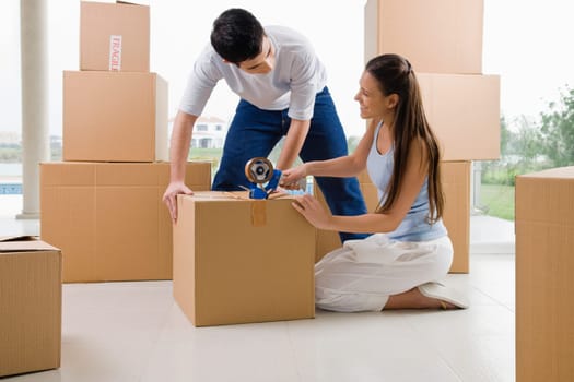 Young couple packing a cardboard box