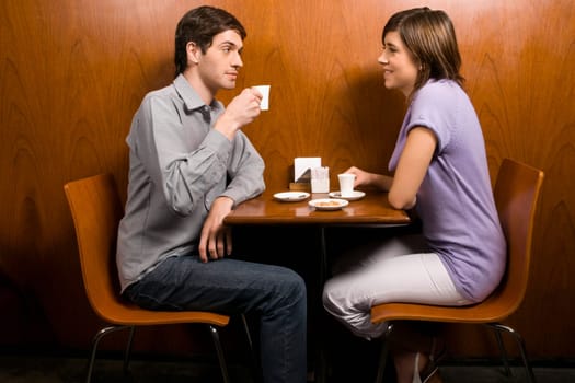 Side profile of a young couple having coffee in a cafe