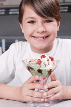 Girl holding a glass of ice cream and smiling