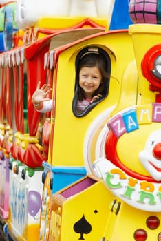 Portrait of a girl waving her hand in a train