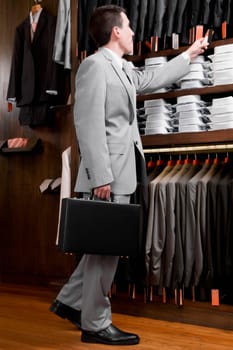 Businessman looking at coats in a clothing store