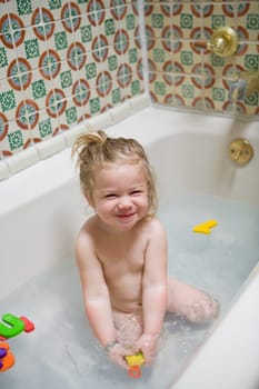 Baby girl smiling in a bathtub