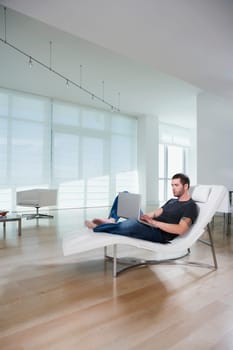 Side profile of a young man using a laptop
