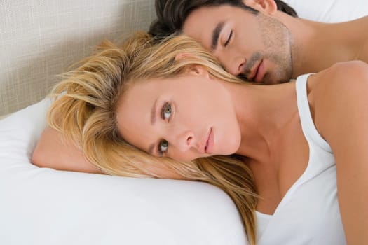 Mid adult woman and a young man lying on the bed