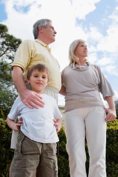 Low angle view of a boy standing with his grandparents in a park