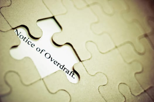 Close_up of a jigsaw puzzle with a notice of overdraft