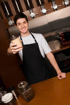 Cafe owner holding a disposable cup at a counter