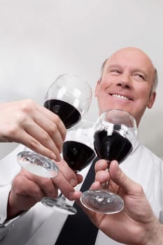 Two men and a woman toasting with wine