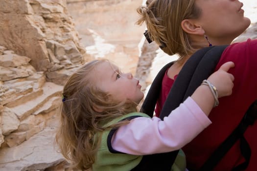 Close_up of a mid adult woman carrying her daughter in a baby carrier