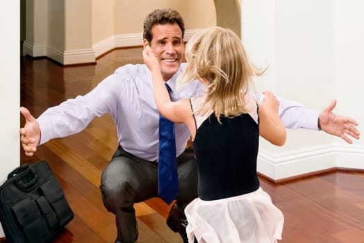 Businessman receiving a warm welcome from his daughter