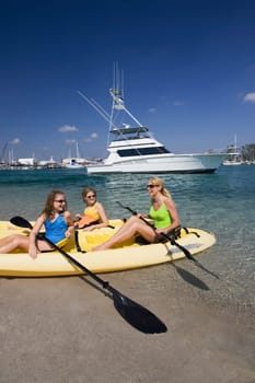 Mature woman with her daughters sitting in a kayak