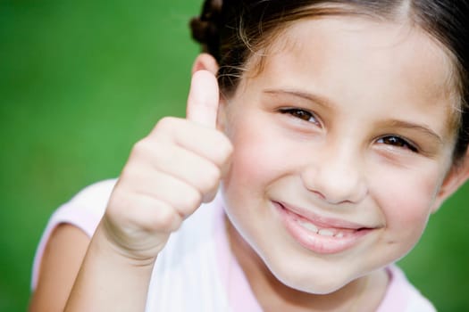 Portrait of a girl smiling and showing a thumbs up sign