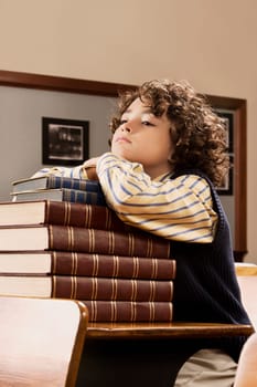 Schoolboy sitting with books in a classroom