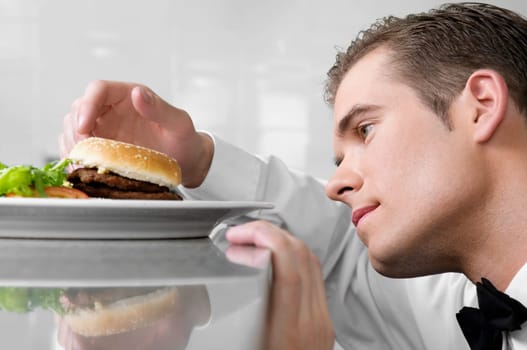 Close_up of a waiter holding a burger