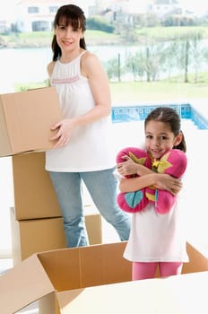 Mature woman holding a cardboard box with her daughter smiling