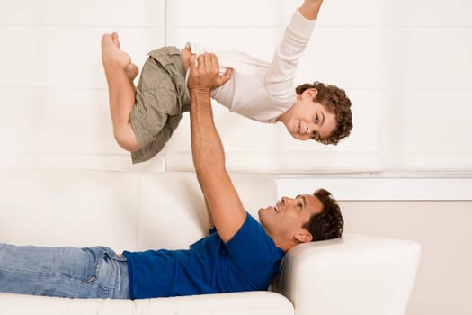 Man playing with his son on a couch
