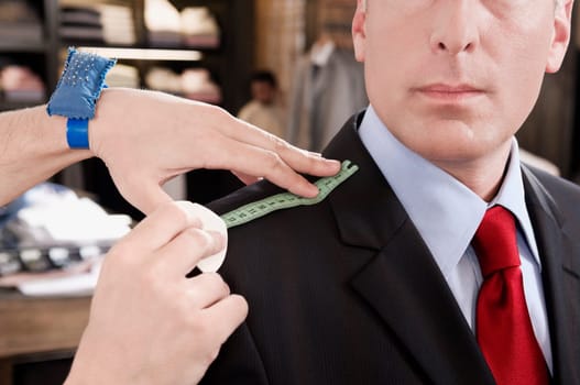 Tailor taking measurement of a businessman