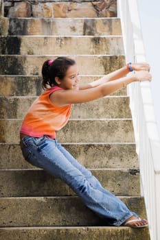 Side profile of a girl holding a railing and standing on the staircase